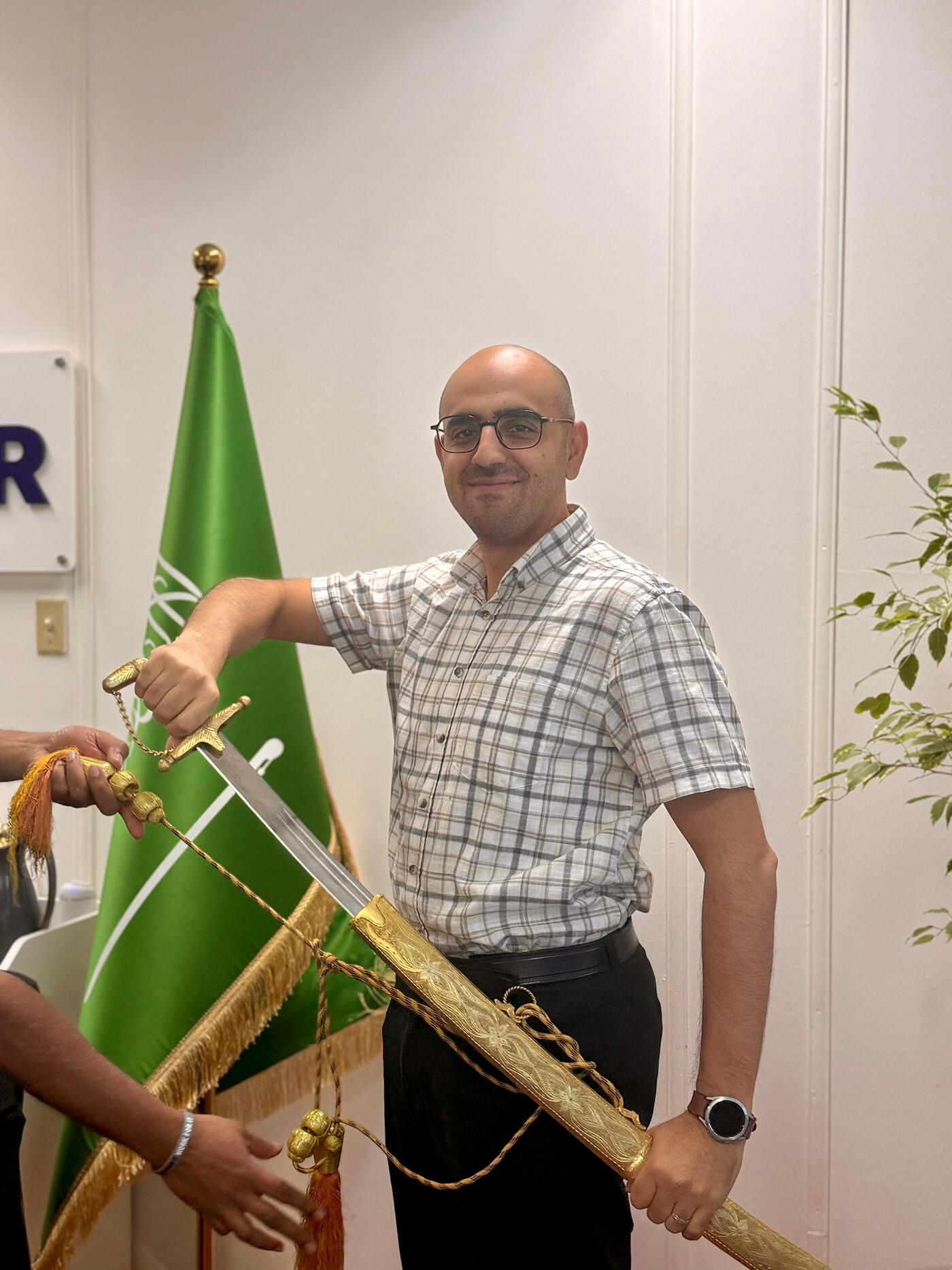 Employee proudly holding ornamental sword