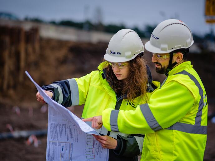 Two engineers referring to a site plan